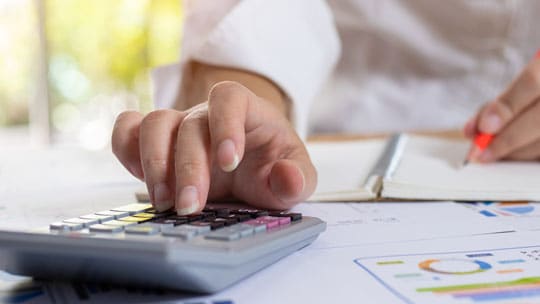 One hand on a calculator.